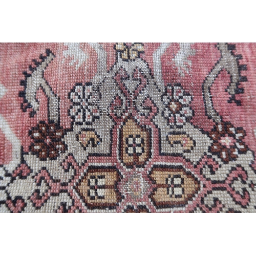 9 - Small Anatolean rug with hooked medallion and stylised floral design in shades of rose, ochre and br... 