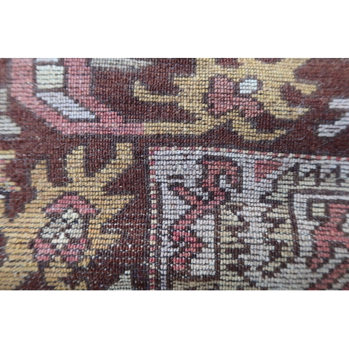 9 - Small Anatolean rug with hooked medallion and stylised floral design in shades of rose, ochre and br... 