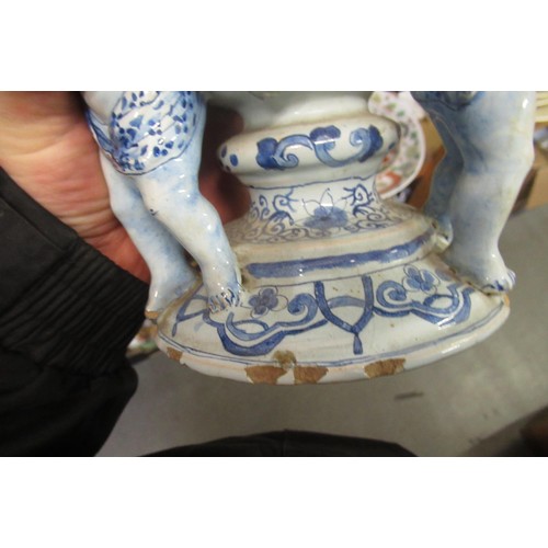 499 - Antique Delft pottery tulip vase on three cherub supports, 27cm high (with damages)