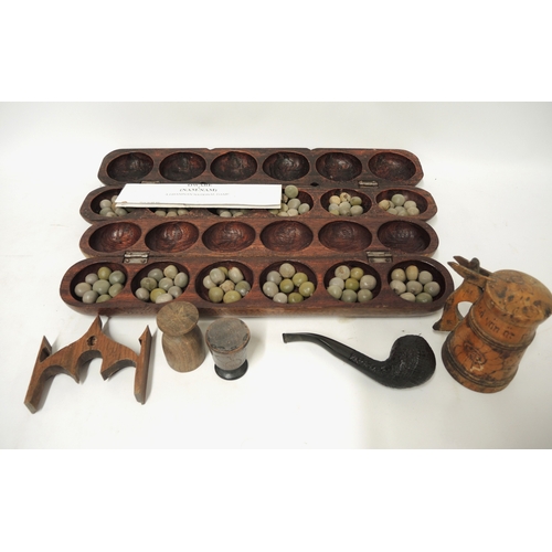145 - Mancala, carved wooden and nut board game, together with a treenware pot inscribed ' Stockholm 1935 ... 