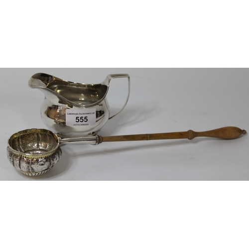 555 - George III silver helmet shaped cream jug on low ball supports, together with an antique white metal... 
