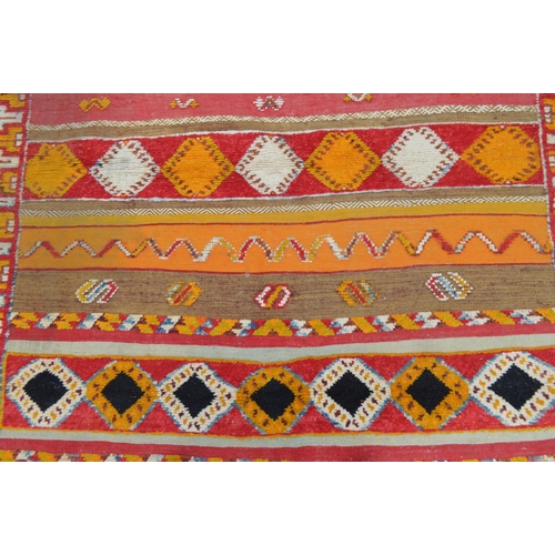 11 - North African rug of flatweave, piled and banded design in shades of orange, cream, red and yellow, ... 