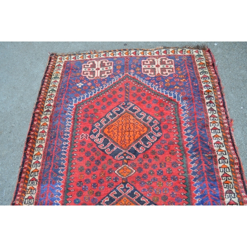 2 - Shiraz rug with centre medallions and multiple borders on a red ground, 193 x 132cm
