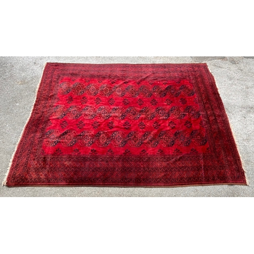 7 - Large Afghan carpet with three rows of ten gols on a wine red ground with multiple borders, 458 x 33... 