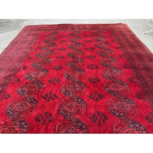 7 - Large Afghan carpet with three rows of ten gols on a wine red ground with multiple borders, 458 x 33... 