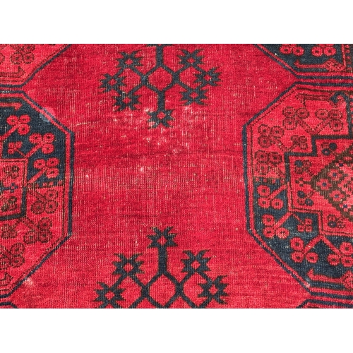 7 - Large Afghan carpet with three rows of ten gols on a wine red ground with multiple borders, 458 x 33... 