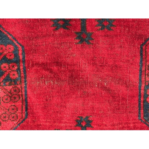 7 - Large Afghan carpet with three rows of ten gols on a wine red ground with multiple borders, 458 x 33... 