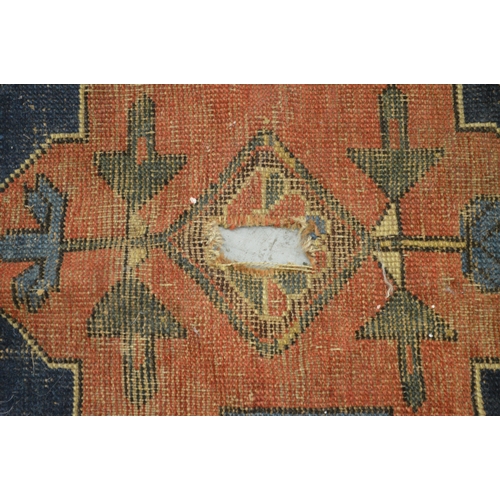 142 - Kazak rug having medallion design with red and blue ground having multiple borders (at fault)