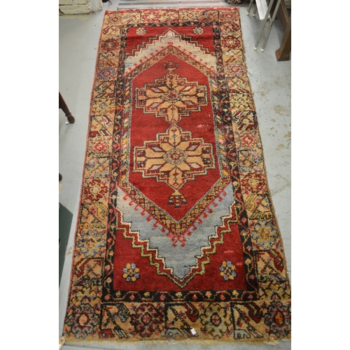 151 - Yahyali (Turkish) rug with a twin medallion design on a red ground with borders, 230 x 107cm approxi... 