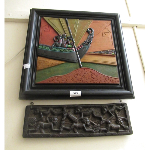 579 - African relief carved wall panel, figures on a boat, with accompanying carved hanging panel