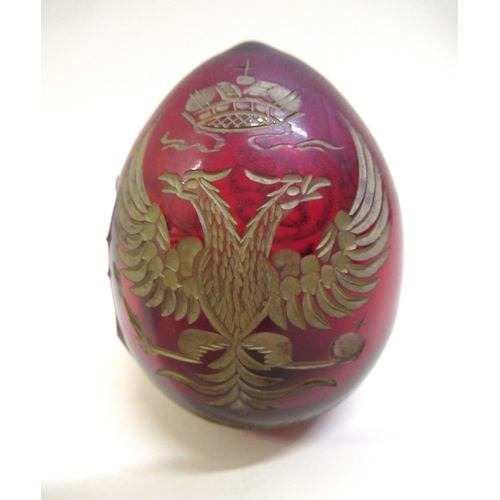 752 - Modern Fabergé gilt decorated ruby glass egg, 7.5cm high, together with a blue and white pottery car... 