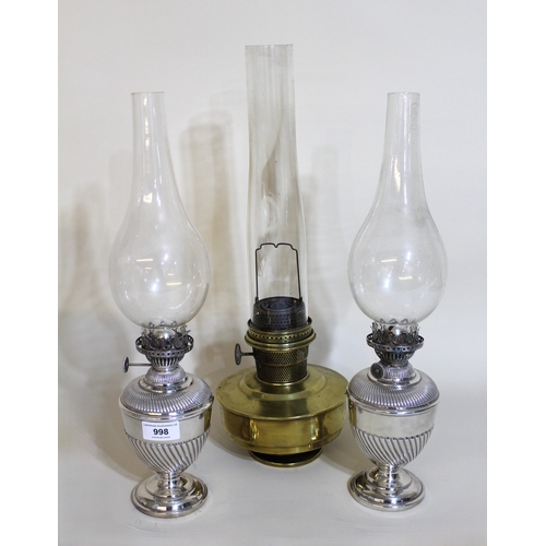 998 - Pair of silver plated oil lamps with glass chimneys, together with a brass oil lamp