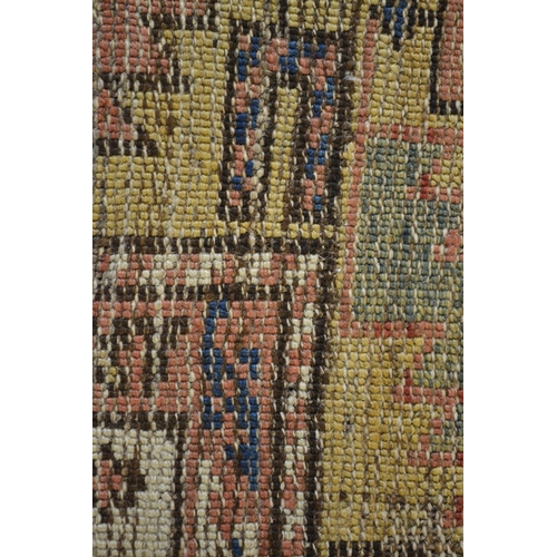 15 - Small Kazak rug with a repeating flower head design on an off-white ground with borders (damages and... 