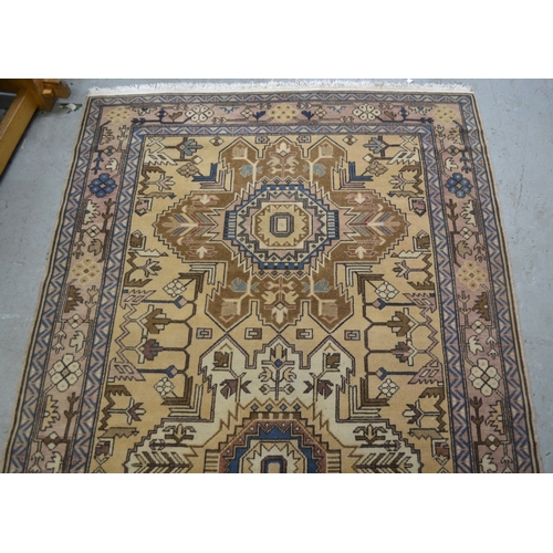 18 - Kurdish rug with triple medallion design on a beige ground with borders, 226 x 125cm approximately