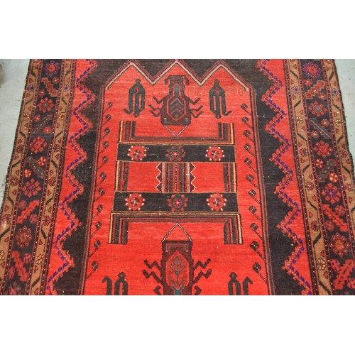 24 - Large Kurdish rug with a geometric red ground centre medallion on a dark ground with further stylise... 
