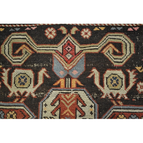 27 - Kazak rug with stylised ram's horn and geometric designs on a brown ground with twin border, 140 x 1... 