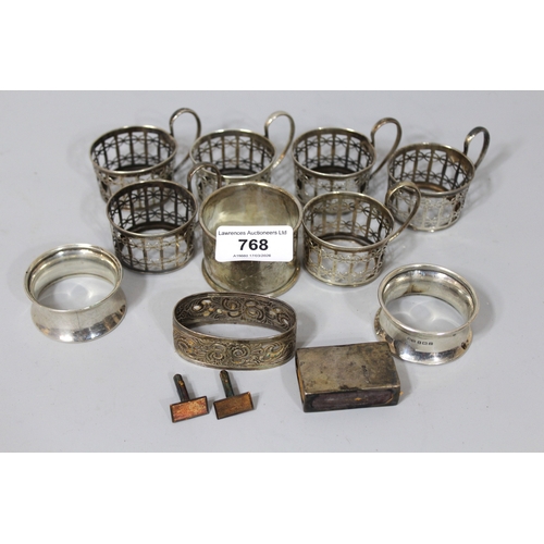 768 - Miscellaneous items of small silver, to include five cup holders, various napkin rings, matchbox hol... 