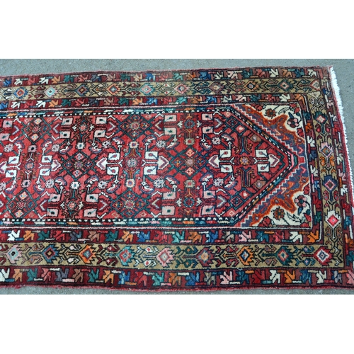 14 - Hamadan runner with all over Herati design on a red ground, 298 nx 101cm