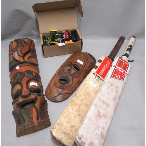 338 - Two wooden wall masks, two cricket bats and a small quantity of model vehicles
