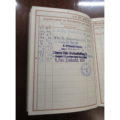 359 - Six German World War II pass books, associated papers and badges