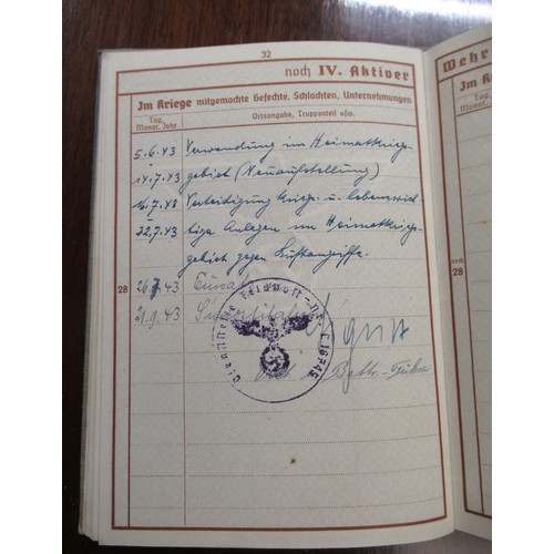 359 - Six German World War II pass books, associated papers and badges