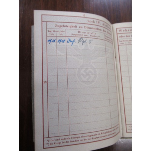 359 - Six German World War II pass books, associated papers and badges