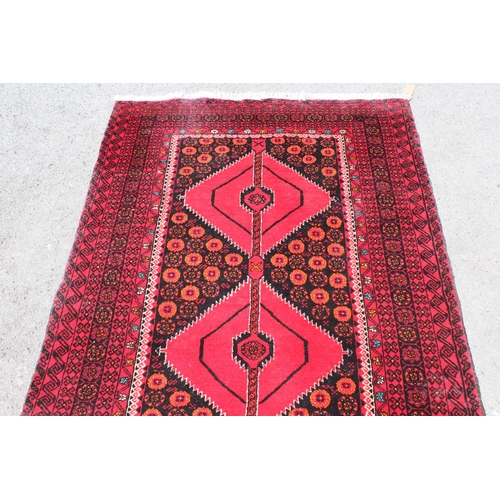 4 - Belouch rug with a triple medallion design on a dark ground with multiple borders, 210 x 108cm appro... 