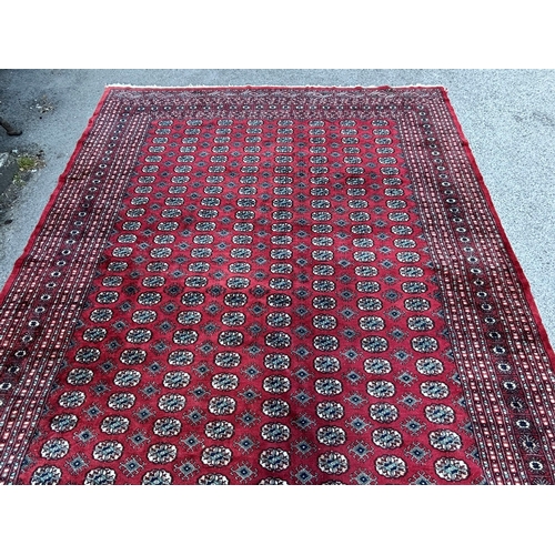 5 - Pakistan Bokhara carpet with eight rows of twenty eight gols on a wine red ground with multiple bord... 