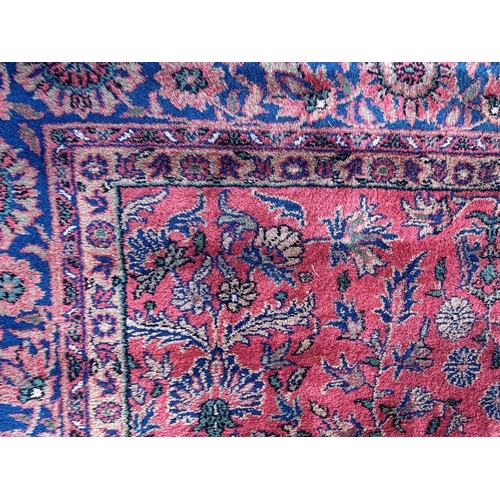 7 - Sparta carpet with an all-over stylised floral design on a pink ground with borders, 356 x 278cm