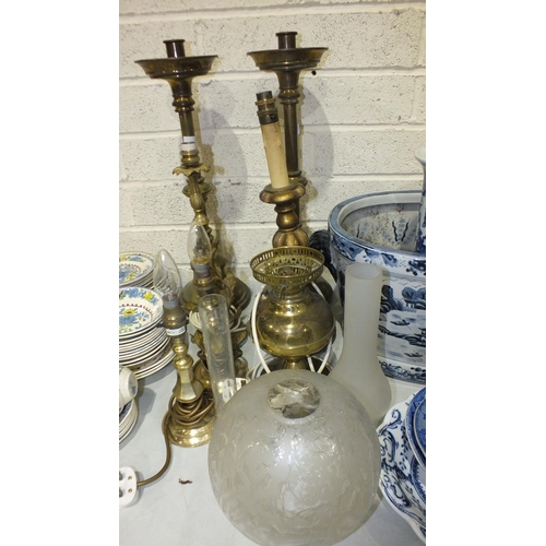 102 - A pair of heavy brass loaded-base church candlesticks, 57cm high and other table lamps.