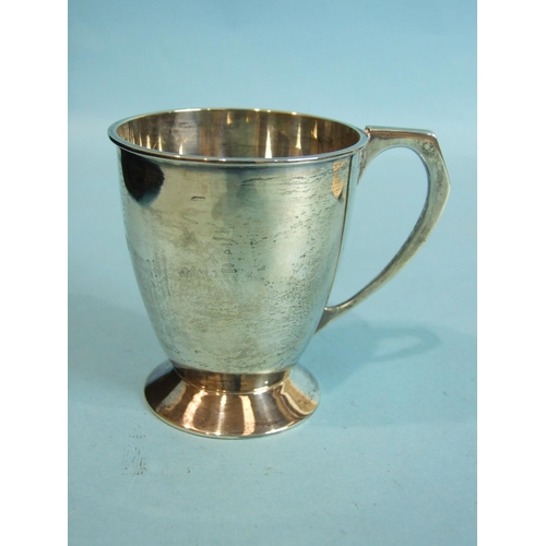 19 - A plain christening mug on spreading foot, with angular handle, 8.5cm high, Birmingham 1932, maker D... 