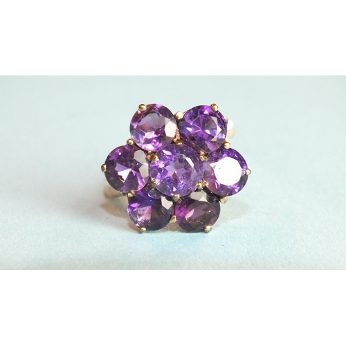 283 - A 9ct gold ring set seven-stone amethyst flower head cluster, size O, 3.9g.