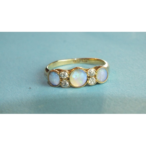 288 - An opal and diamond ring millegrain-set three opals, with pairs of brilliant-cut diamonds between, i... 