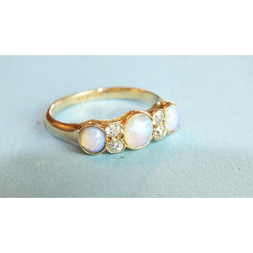 288 - An opal and diamond ring millegrain-set three opals, with pairs of brilliant-cut diamonds between, i... 