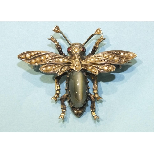 298 - A silver bee brooch claw-set a chrysoberyl cat's eye, with pearl-set wings and red paste eyes, unmar... 