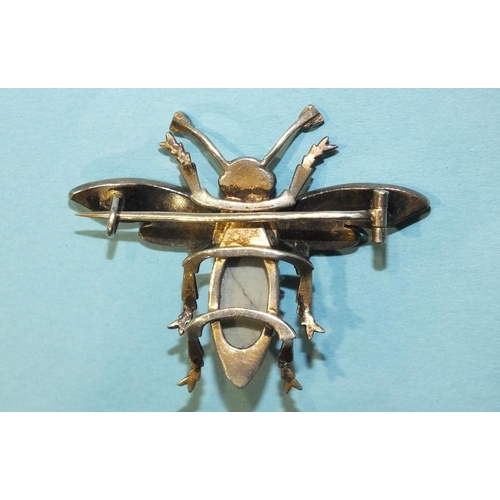 298 - A silver bee brooch claw-set a chrysoberyl cat's eye, with pearl-set wings and red paste eyes, unmar... 