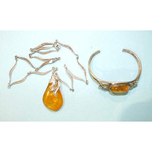 302 - A silver-mounted amber pendant on leaf-link silver chain and a silver bangle set amber, (2).