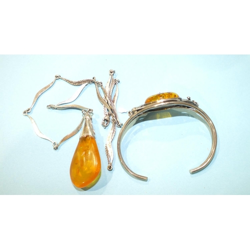 302 - A silver-mounted amber pendant on leaf-link silver chain and a silver bangle set amber, (2).