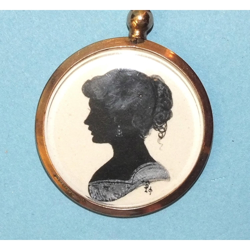 342 - A small Edwardian circular locket pendant containing a silhouette of a young lady, painted in black ... 