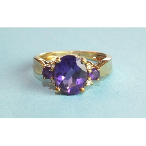 349 - An amethyst ring claw-set an oval amethyst between amethyst and diamond-set shoulders, in 9ct gold m... 