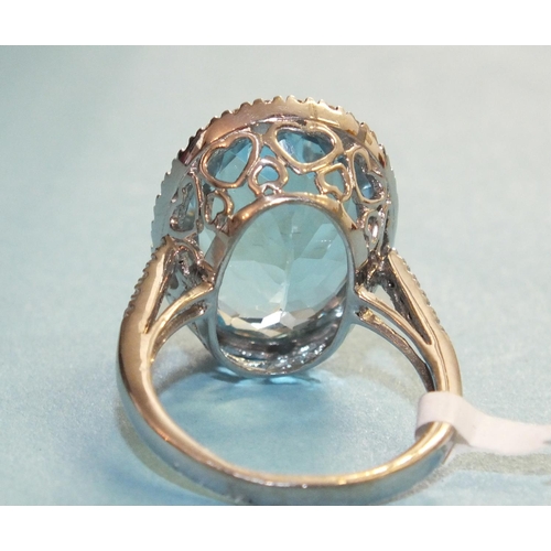 354 - A blue topaz and diamond ring, the oval blue topaz of approximately 13.2cts, within a surround of tw... 