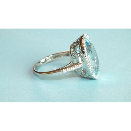 354 - A blue topaz and diamond ring, the oval blue topaz of approximately 13.2cts, within a surround of tw... 