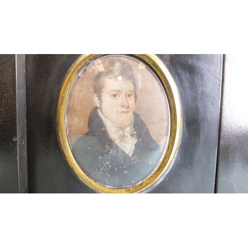 566 - Two 19th century miniature portraits of young men, painted on ivory, each within oval gilt metal bez... 