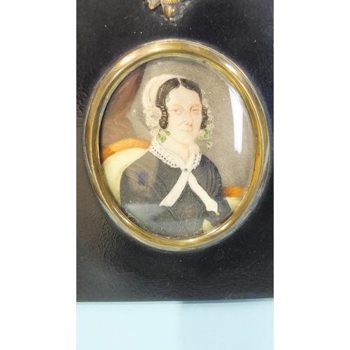 569 - An early 19th century miniature portrait of a lady with a pearl necklace and flowers in her hair, 7.... 