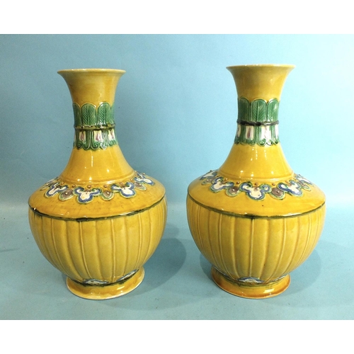 796 - A pair of Chinese yellow ground baluster vases with bands of polychrome moulded decoration, impresse... 