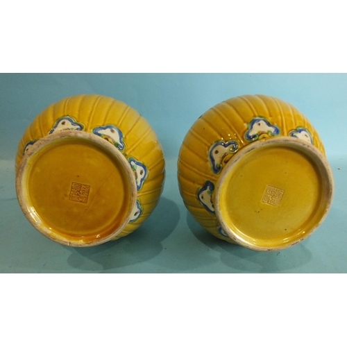 796 - A pair of Chinese yellow ground baluster vases with bands of polychrome moulded decoration, impresse... 