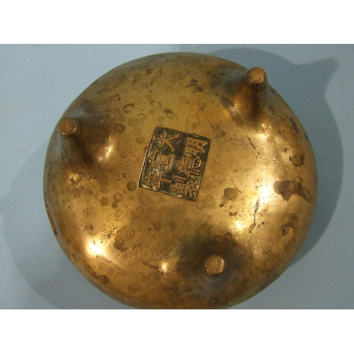 829 - A Chinese bronze metal censer of compressed form, with pierced handles, on three feet, 23cm diameter... 