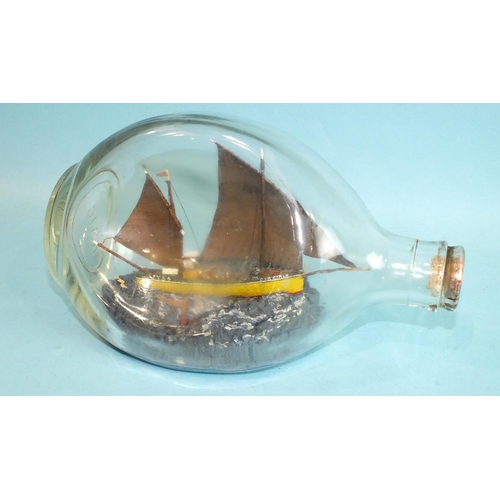 837 - A ship model in a dimple bottle, 'The Fowey Lugger FY54', detail includes a gull and fishing buoy, t... 