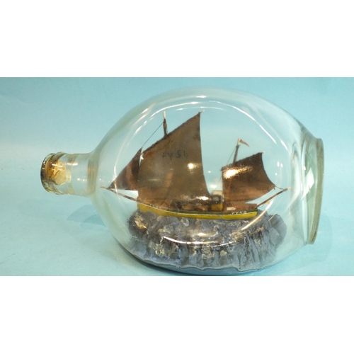 837 - A ship model in a dimple bottle, 'The Fowey Lugger FY54', detail includes a gull and fishing buoy, t... 