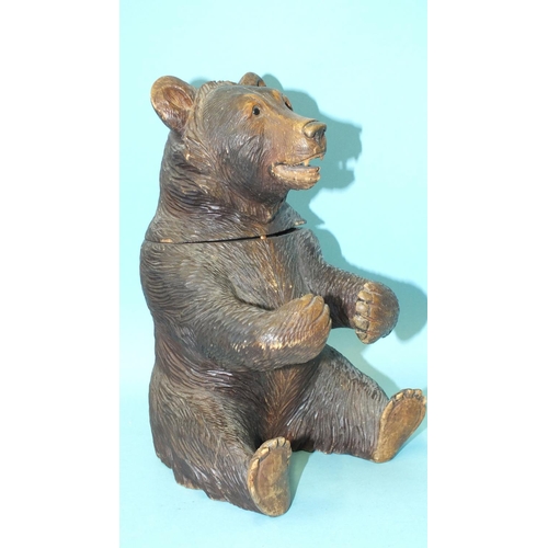 849 - A 19th/20th century carved wood Black Forest tobacco jar and cover in the form of a seated bear, wit... 